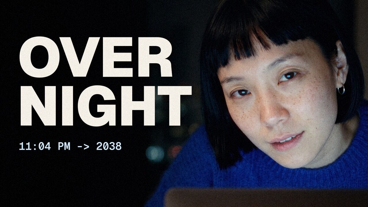 OVERNIGHT music video title card: the singer with a black bob, lit by a laptop at night
